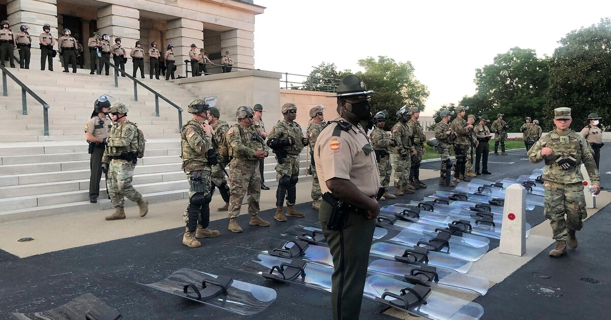 Tennessee National Guard troops lay down riot shields at protesters